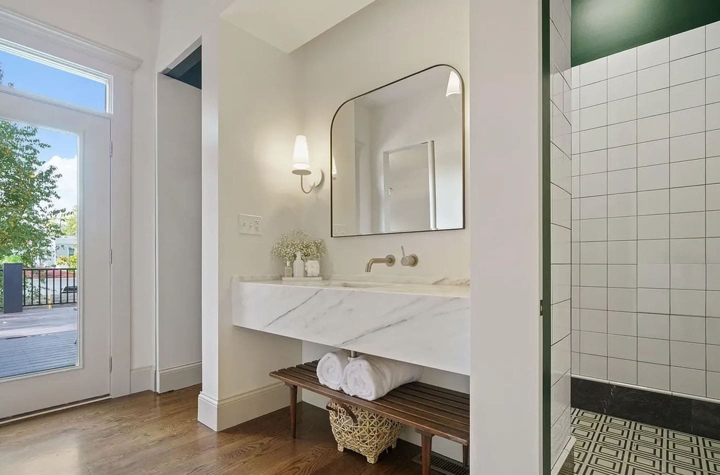 A bathroom with a large mirror and marble counter.