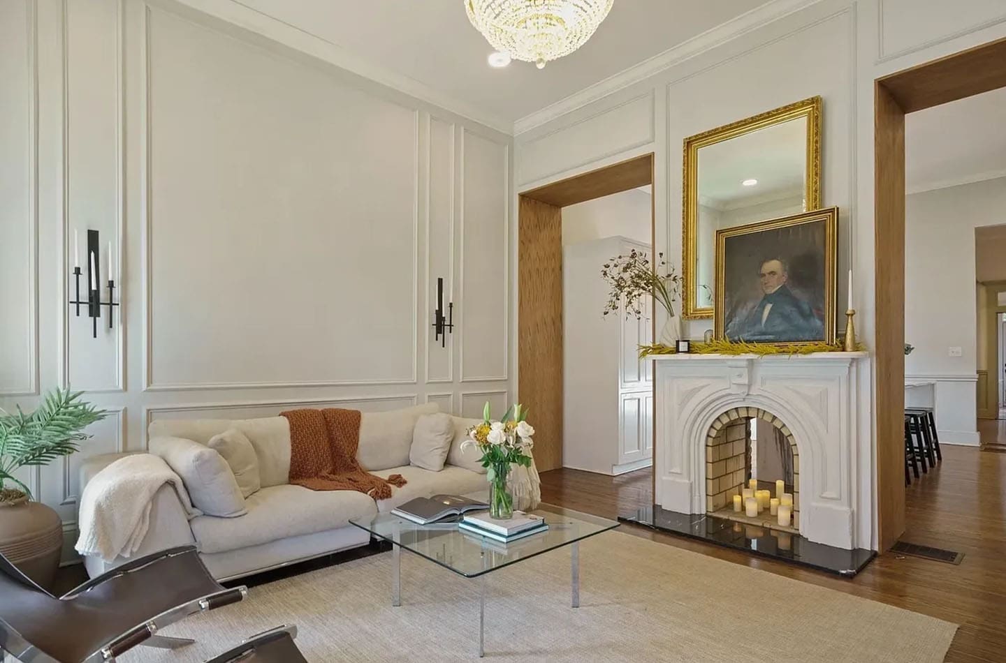 A living room with white furniture and a fireplace.