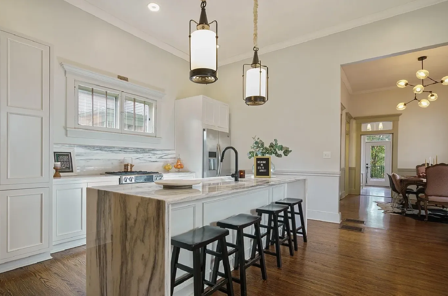 A kitchen with white walls and wooden floors.