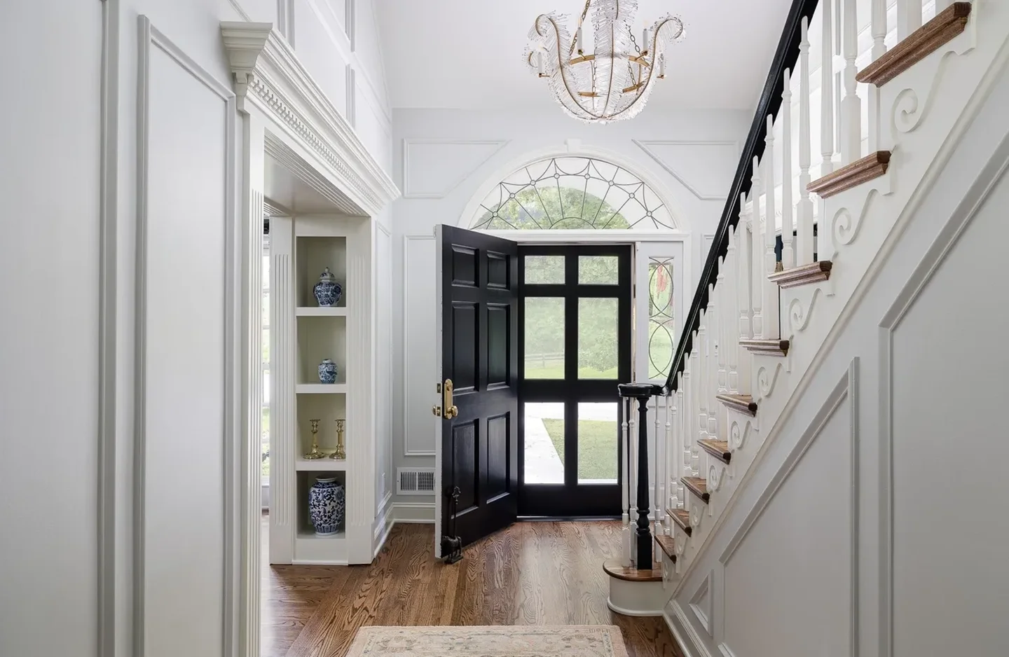 A black door leads to the stairs in this foyer.