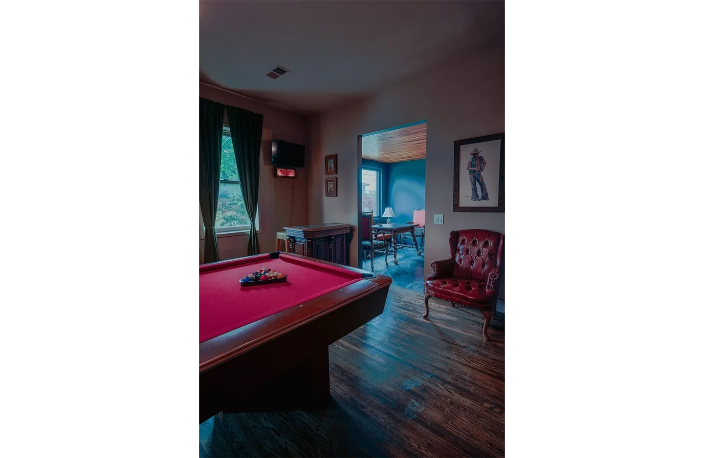 A room with a pool table and chairs