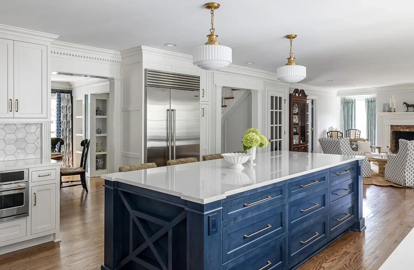 A kitchen with blue cabinets and white counter tops.