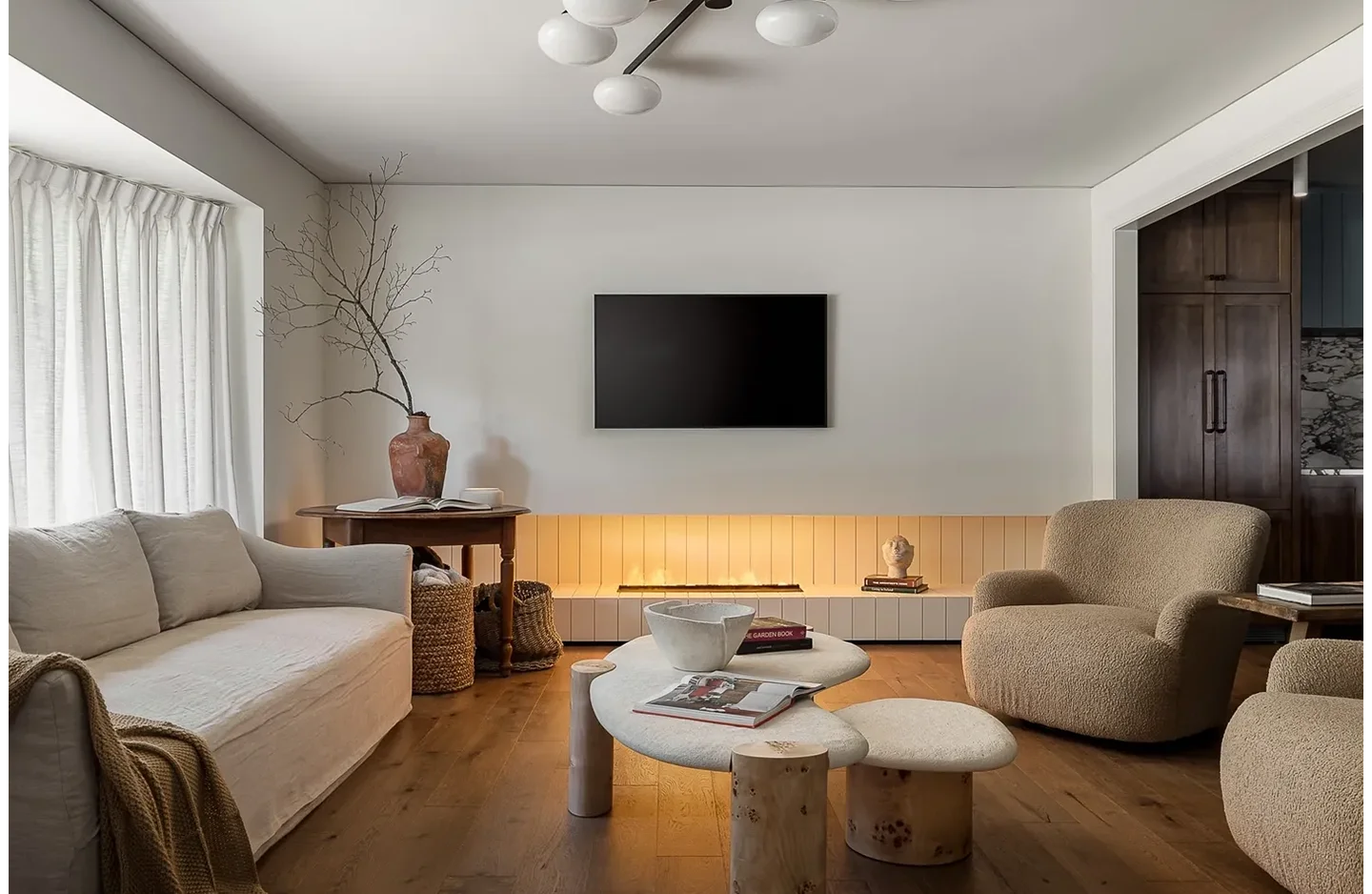 A living room with a couch, chair and television.