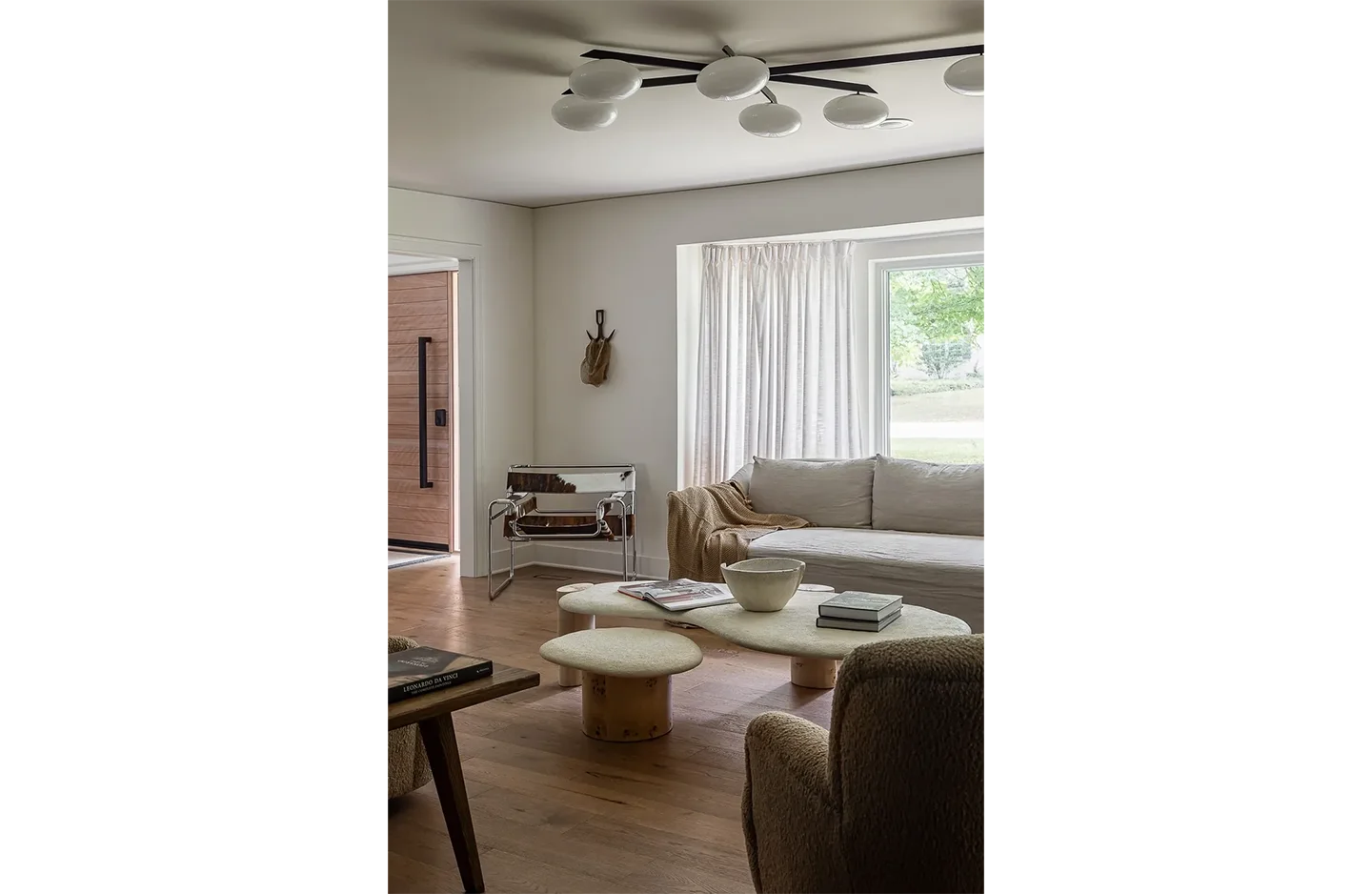 A living room with white furniture and wooden floors.