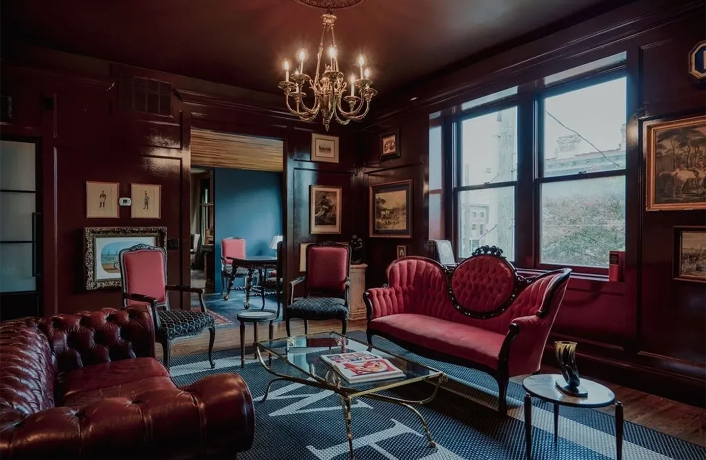 A living room with red furniture and a chandelier.