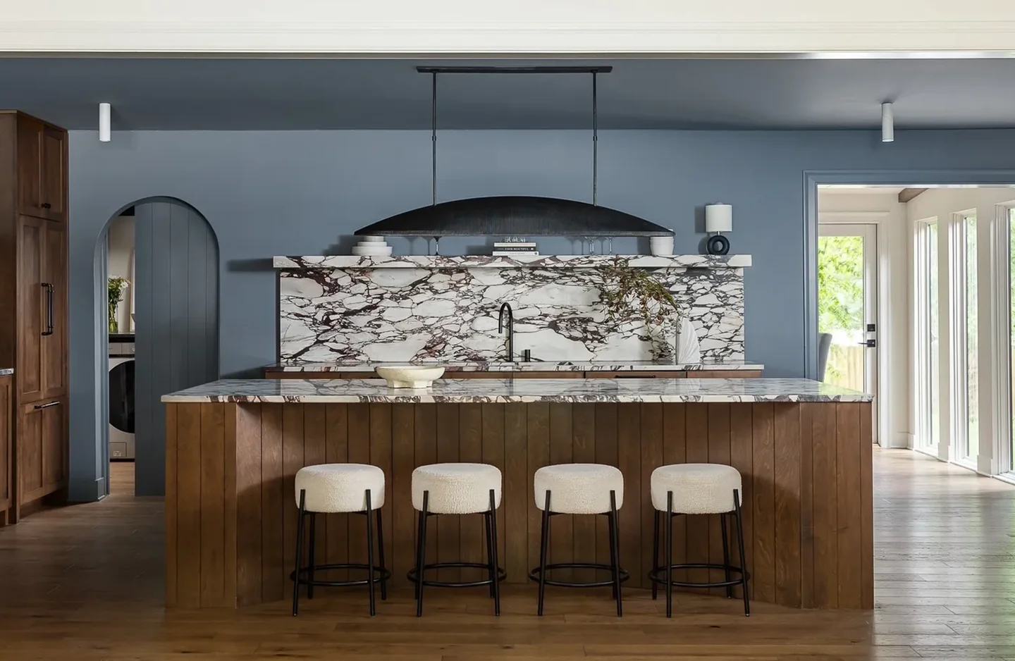 A bar with four stools and a marble counter.