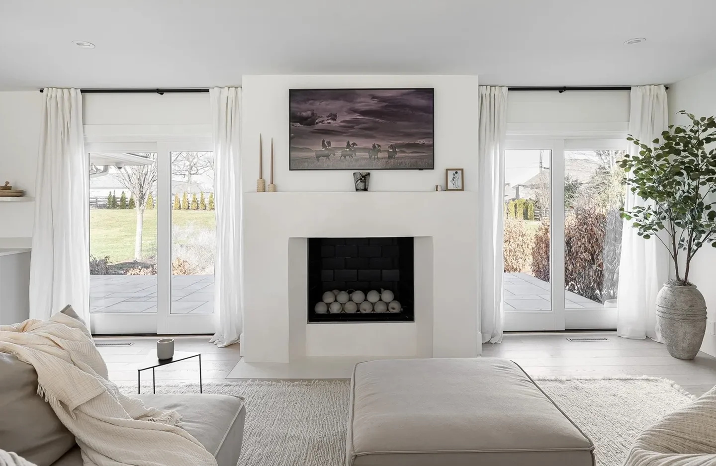 A living room with white walls and fireplace