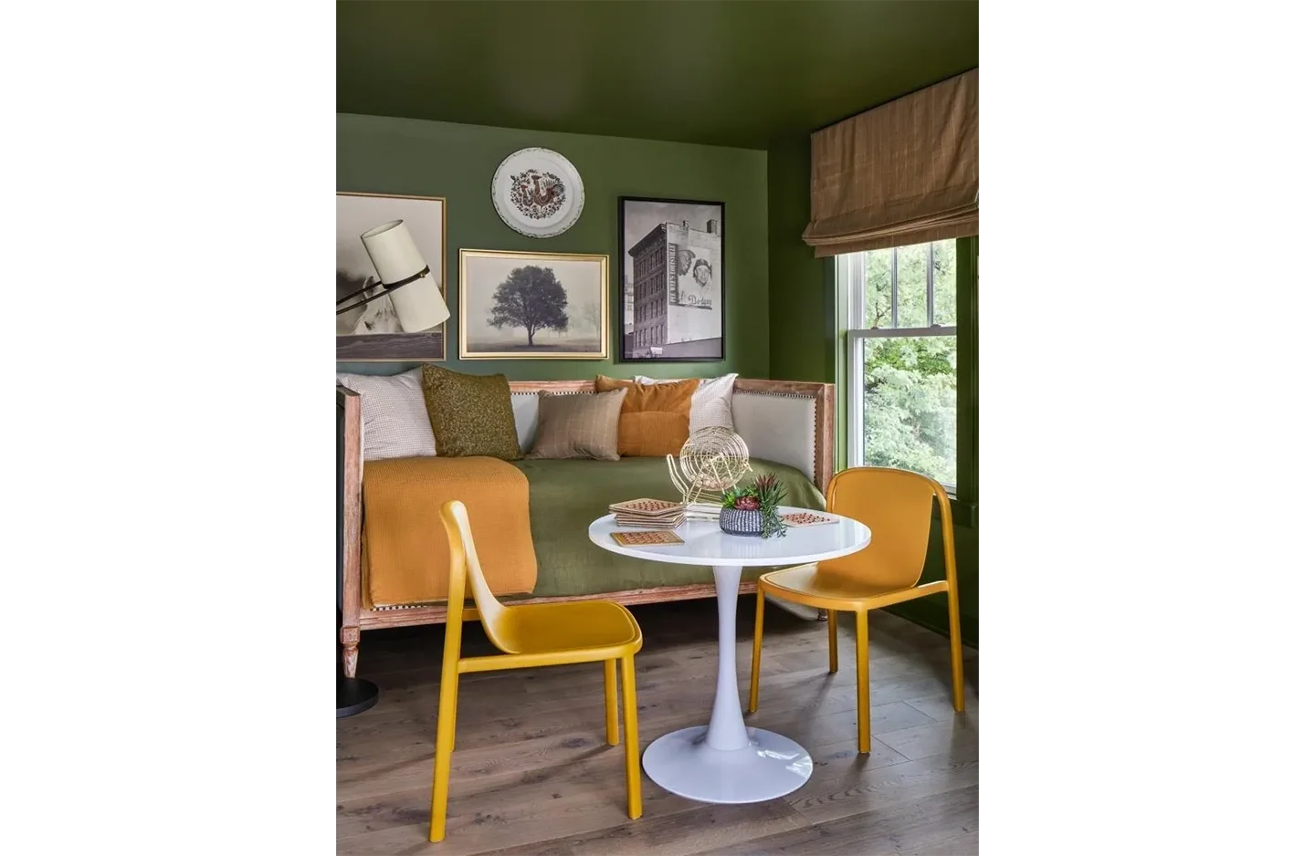 A living room with green walls and yellow chairs.