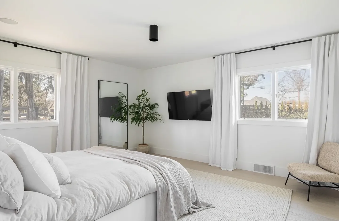 A bedroom with white walls and a large bed.