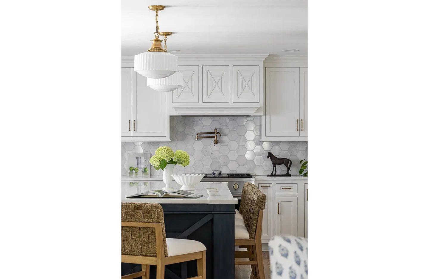 A kitchen with white cabinets and black island.