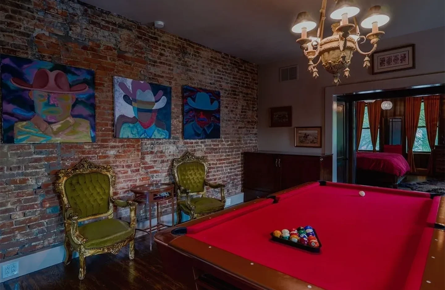 A pool table in the corner of a room with chairs around it.