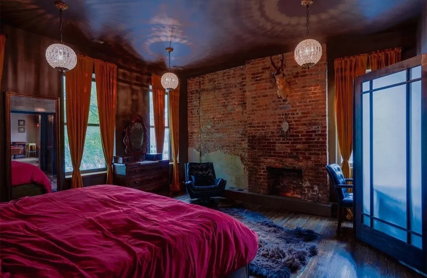 A bedroom with a fireplace and red walls