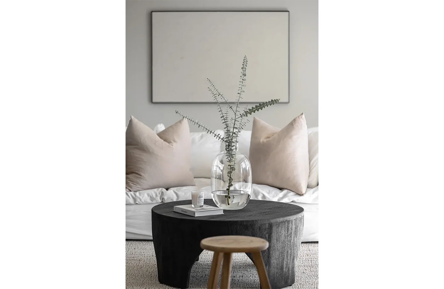 A living room with a round coffee table and a plant in the middle of it.