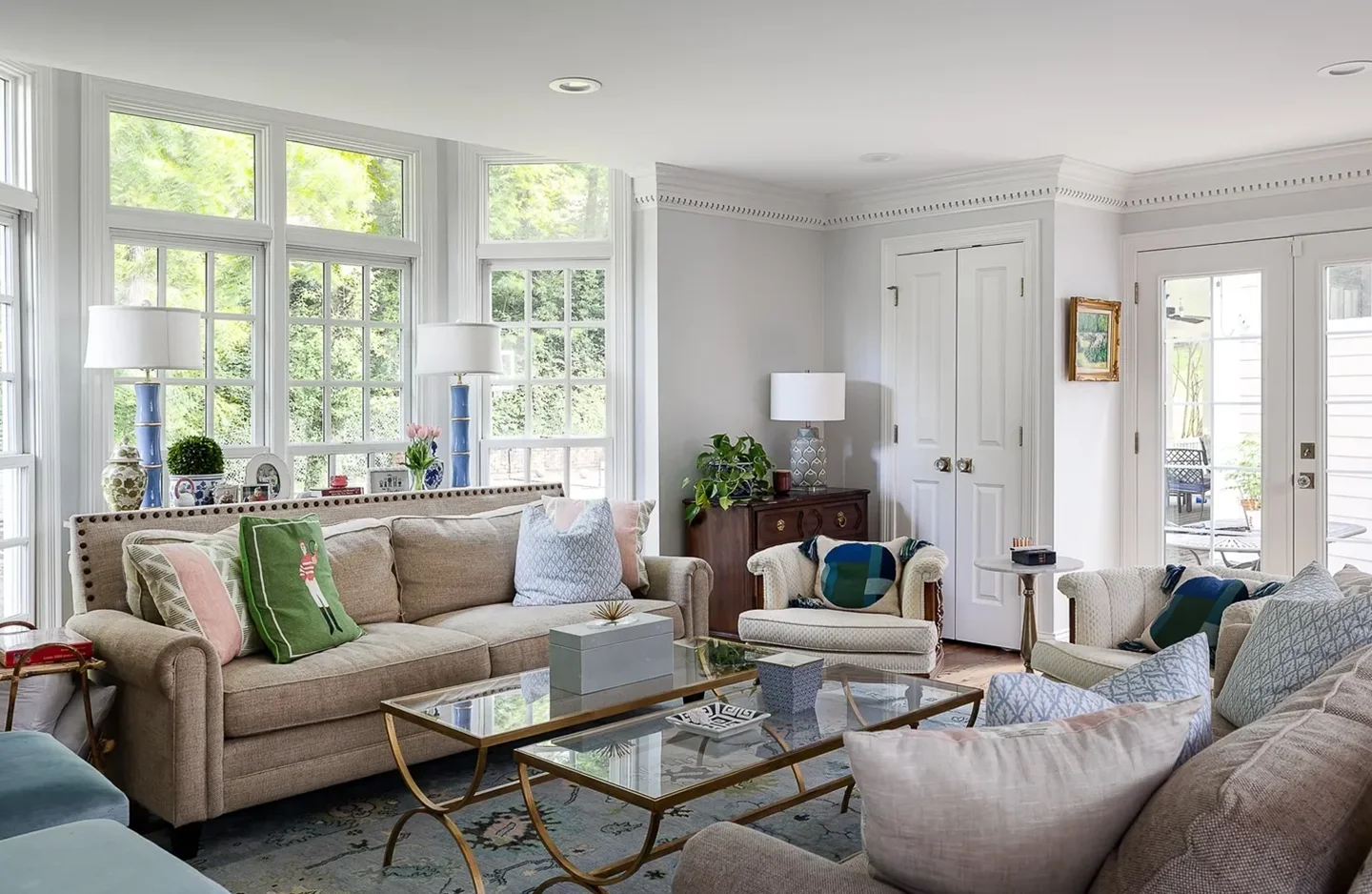 A living room with couches, chairs and tables.