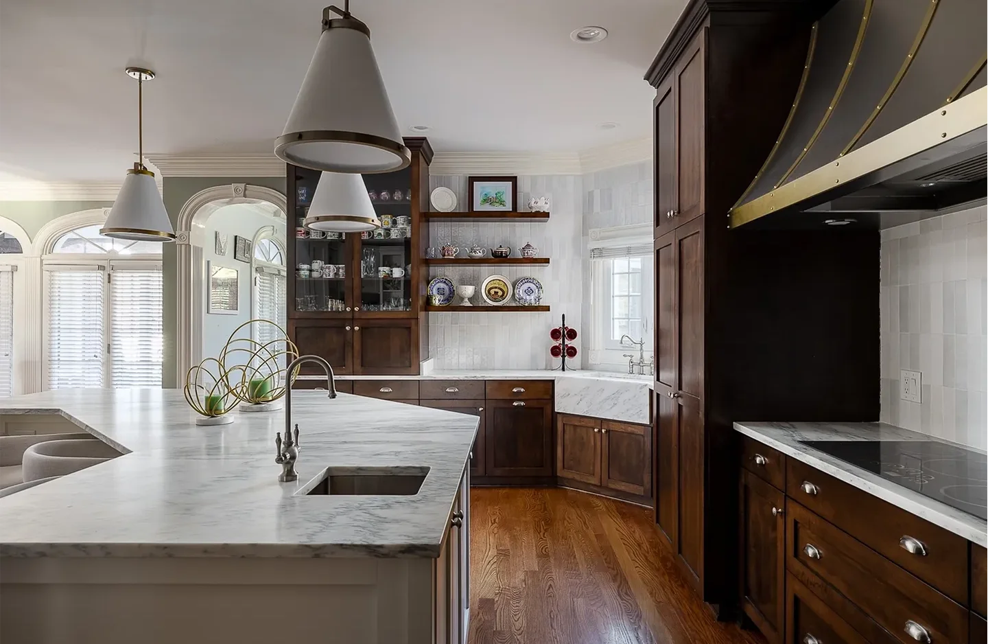 A kitchen with wooden floors and white cabinets.