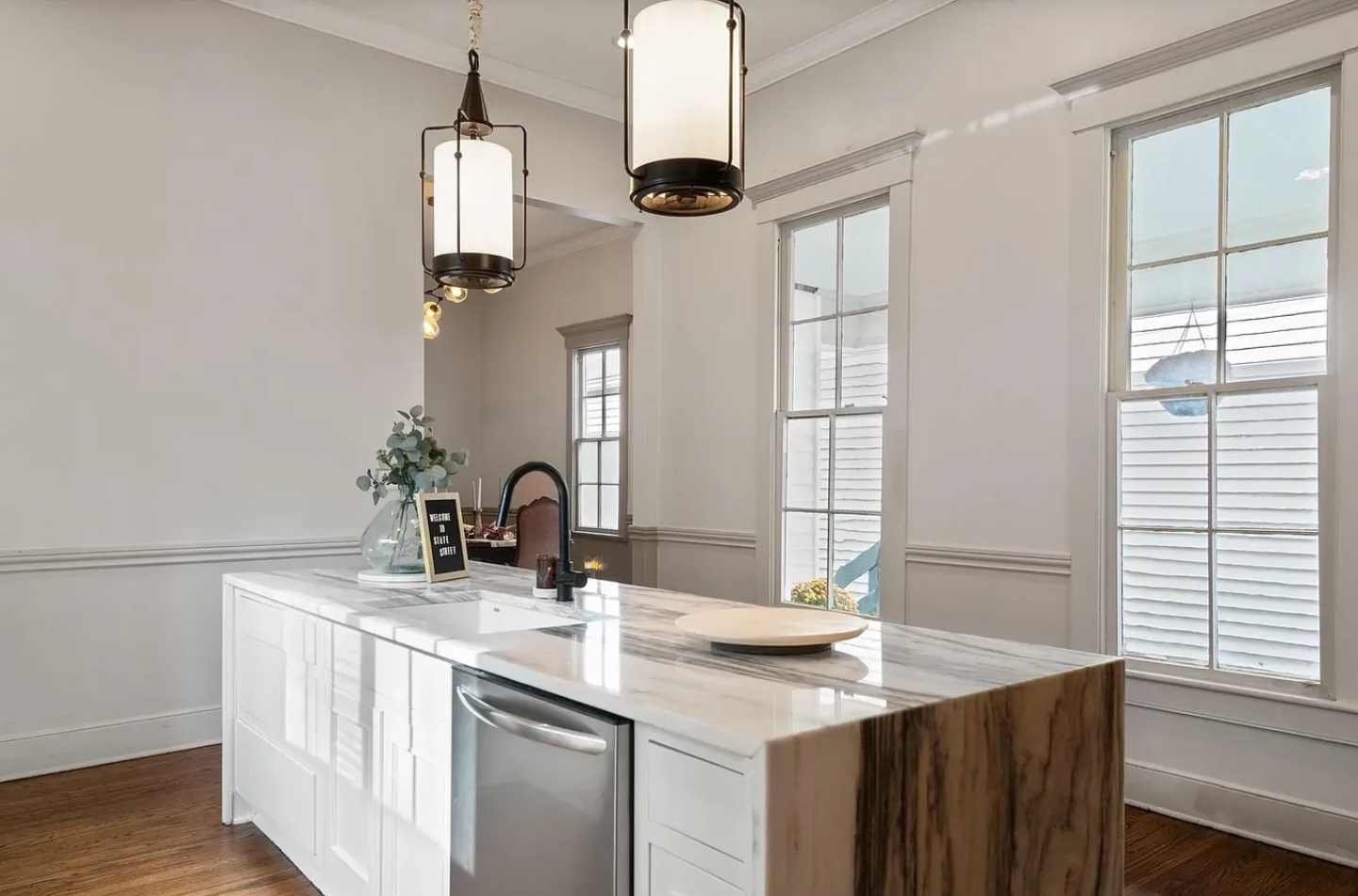 A kitchen with white cabinets and black fixtures.