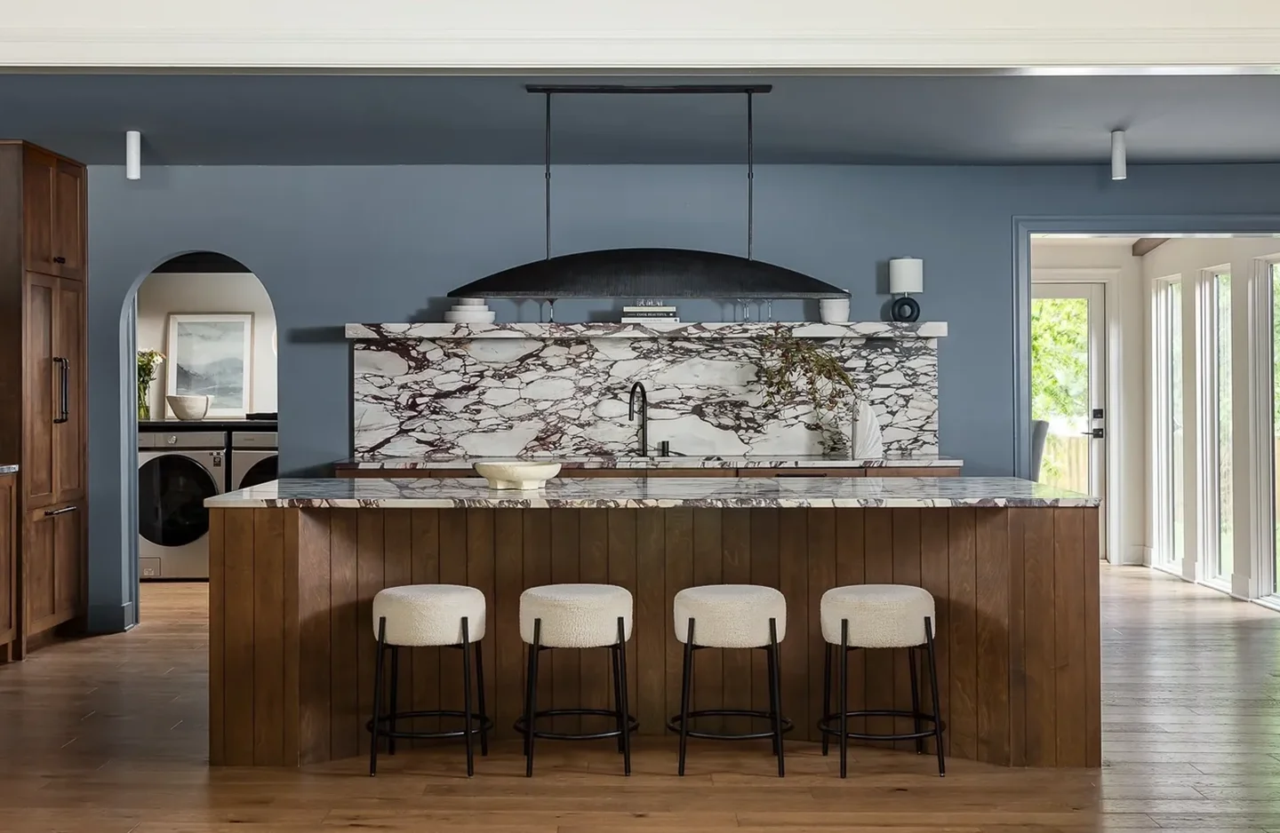 A bar with four chairs and a marble counter.