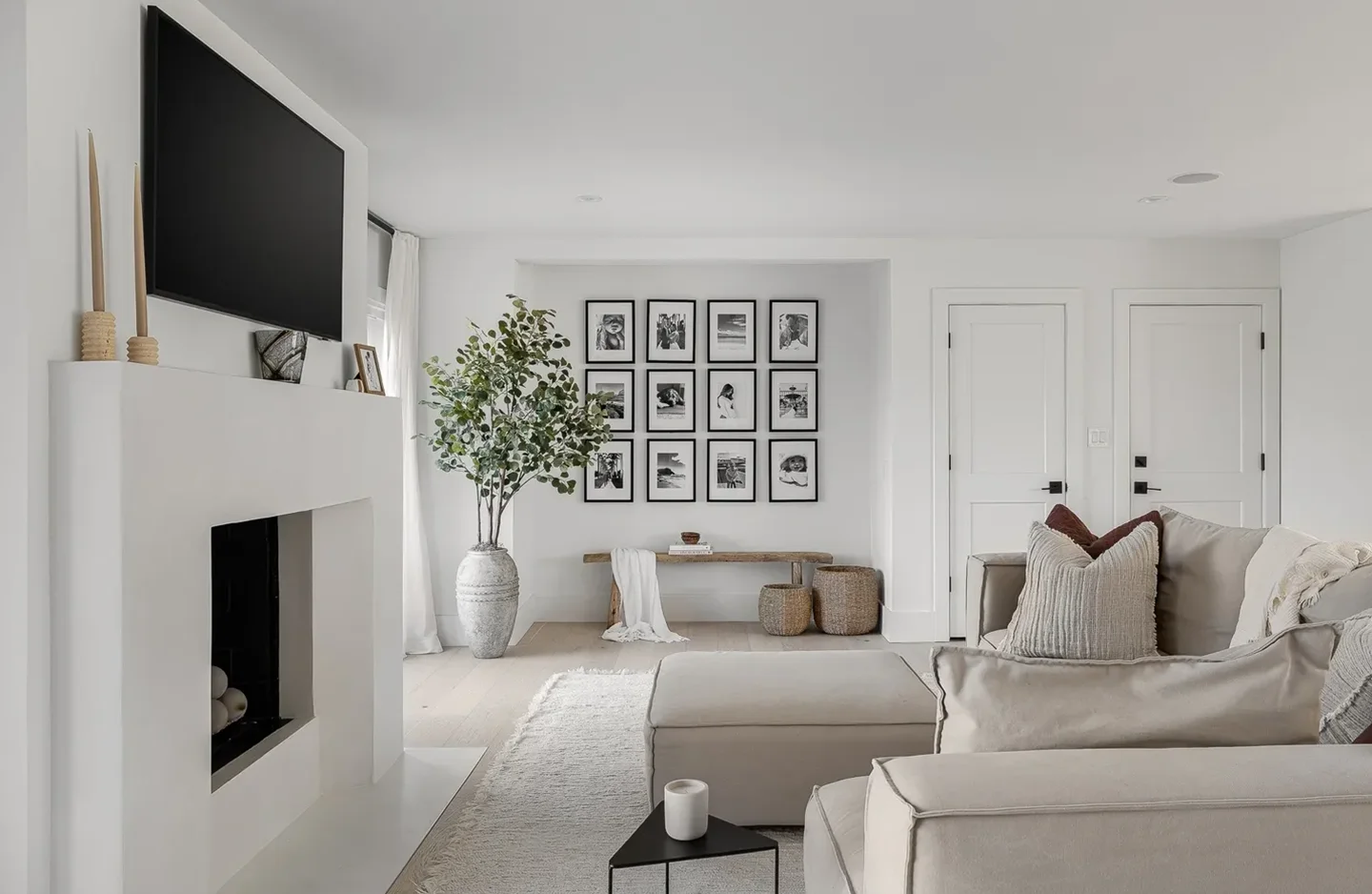 A living room with white furniture and a fireplace.