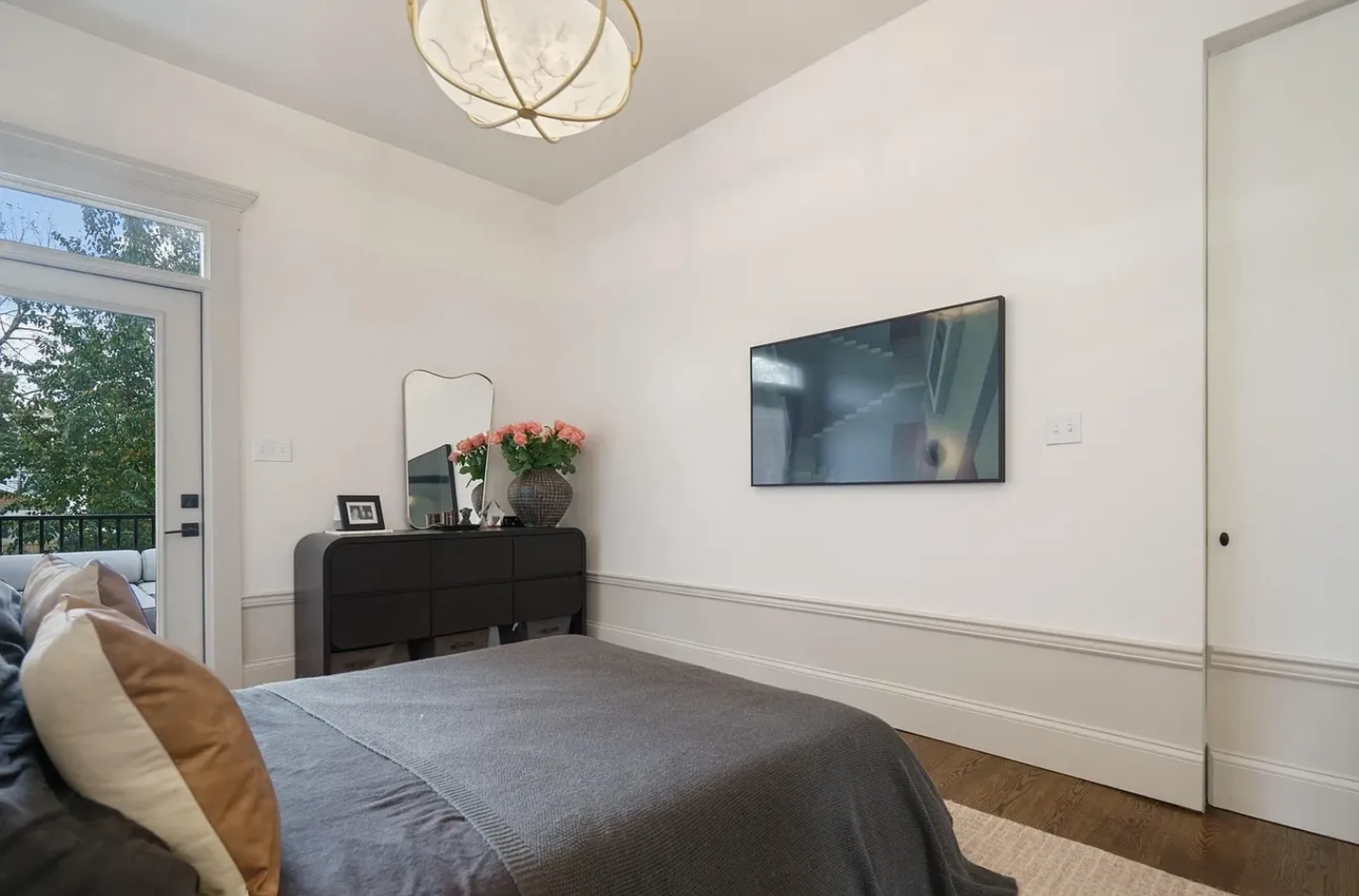 A bedroom with a bed and dresser in it