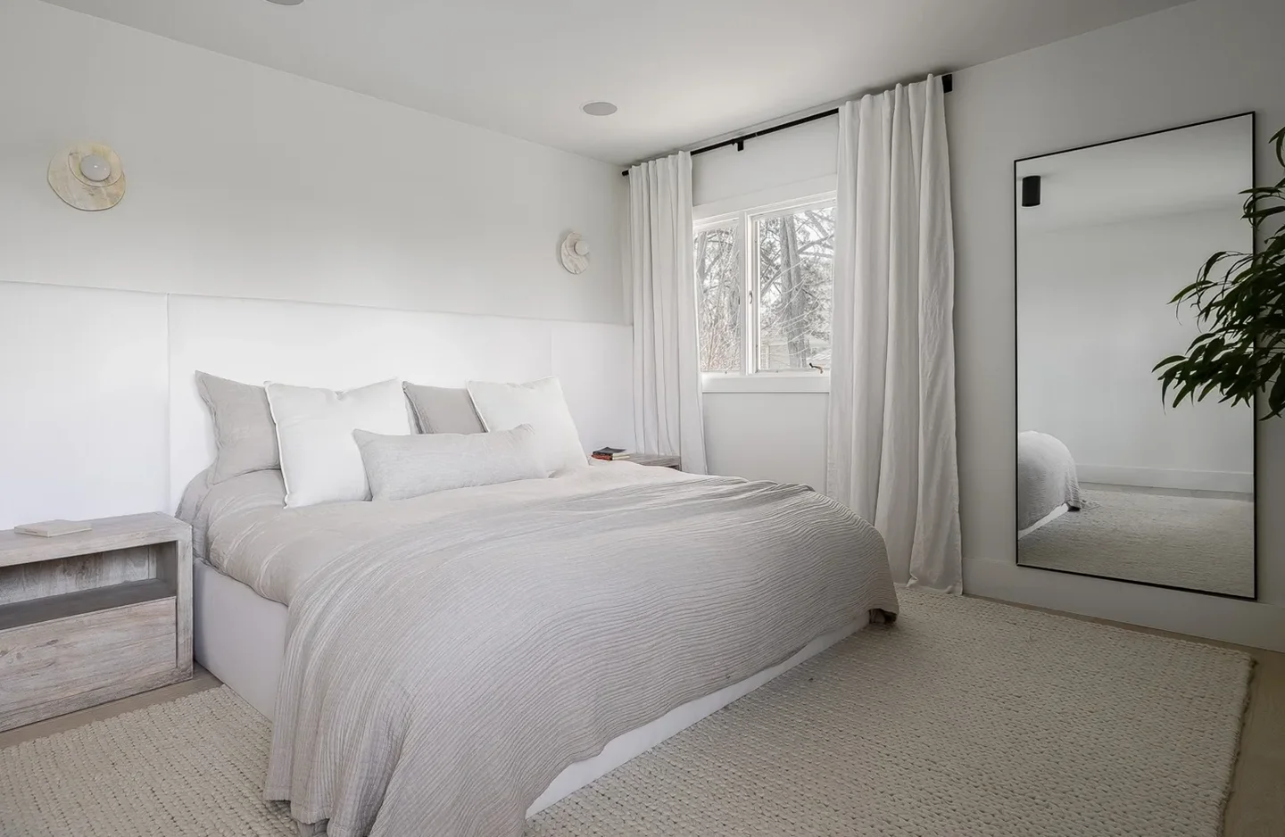 A bedroom with white walls and carpet.