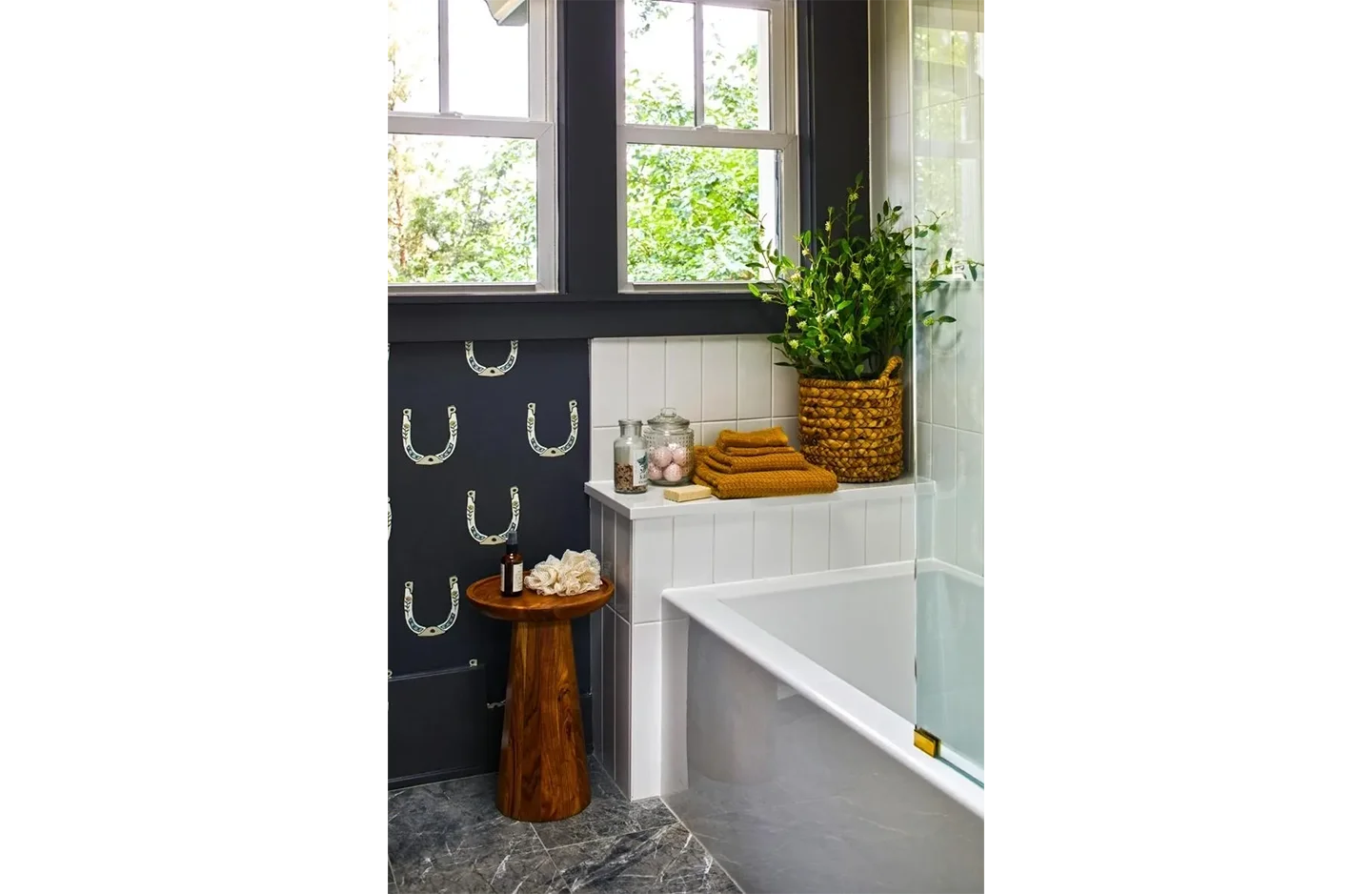 A bathroom with a tub, toilet and window.