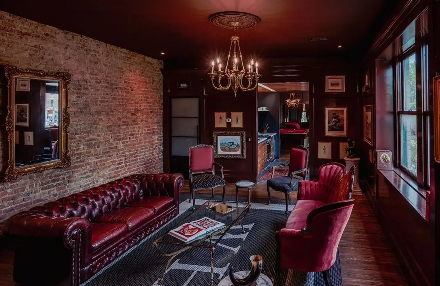 A living room with red furniture and brick walls.