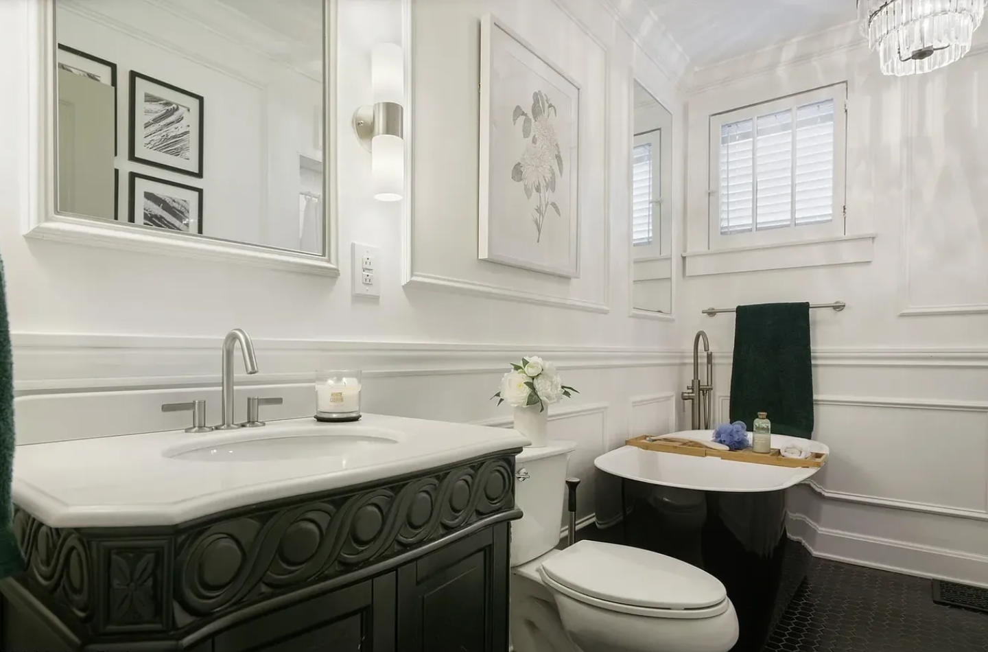 A bathroom with white walls and black cabinets.