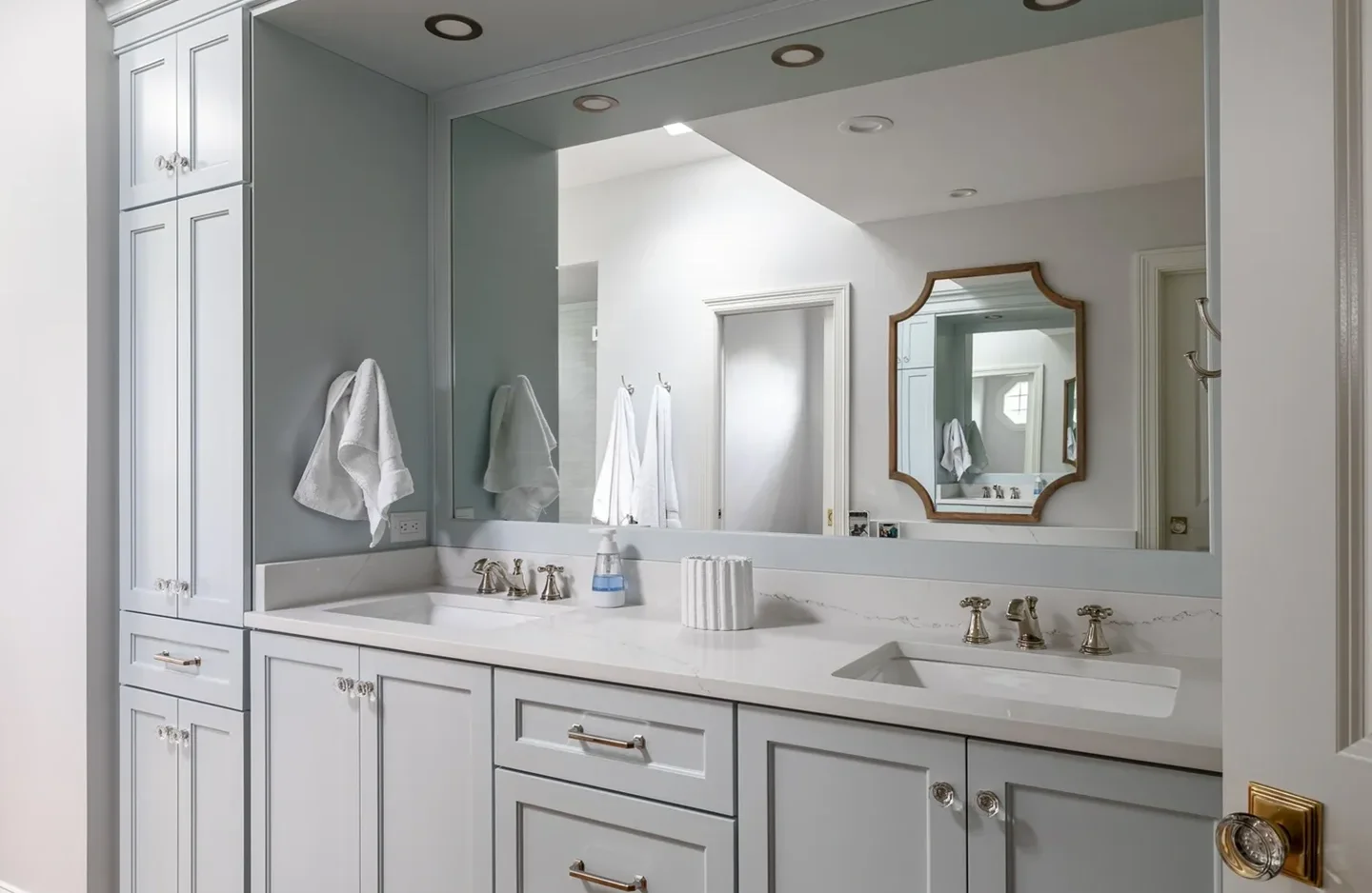 A bathroom with two sinks and a large mirror.