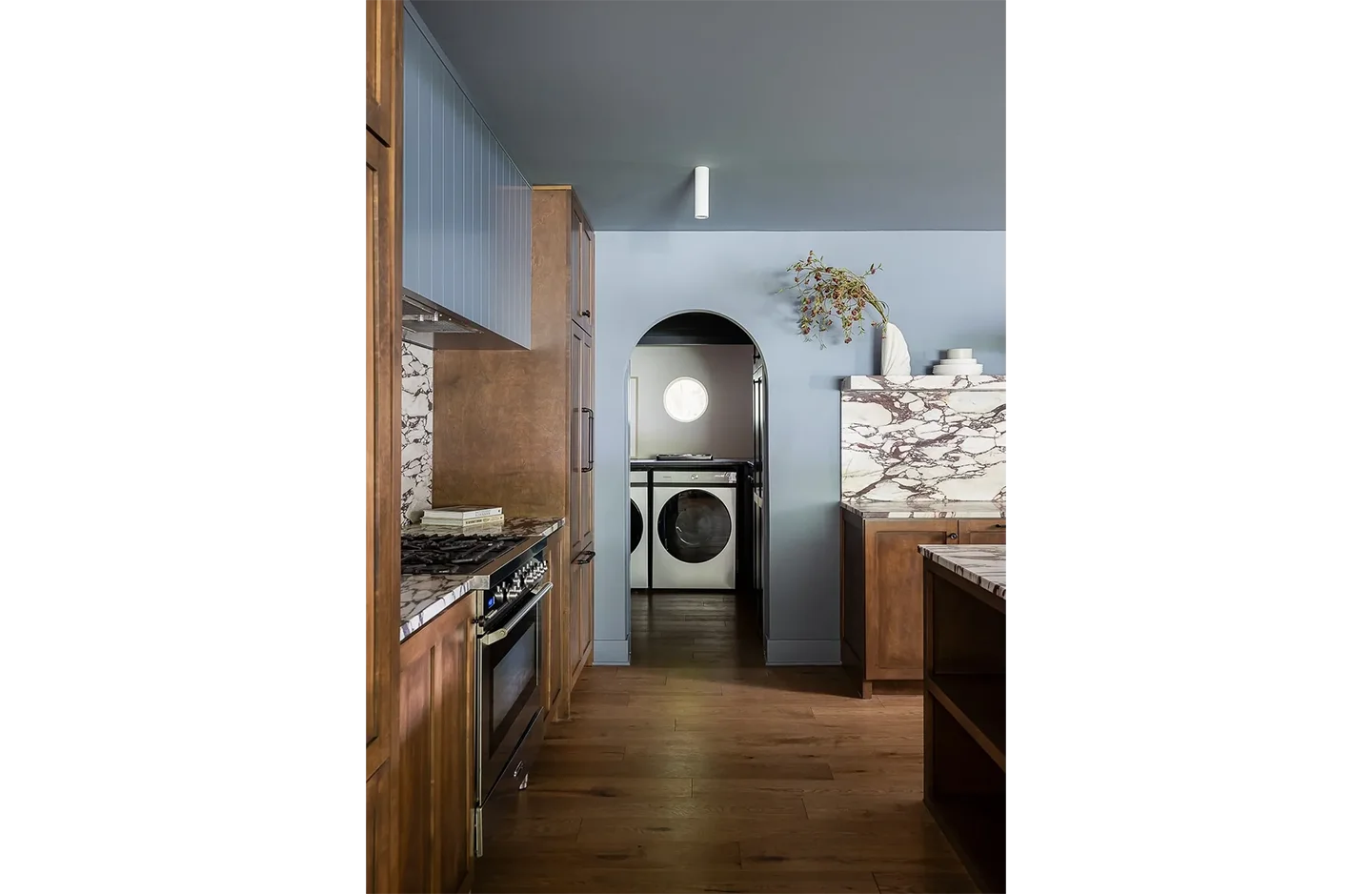 A kitchen with wood floors and a washer dryer.