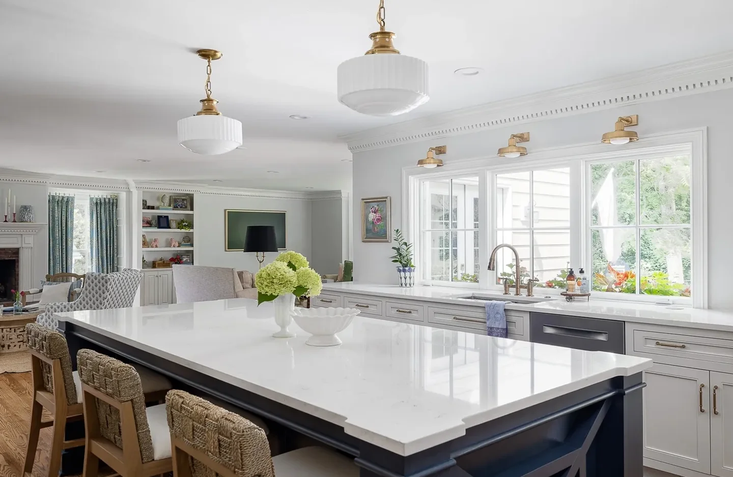 A large kitchen with white counters and a big window