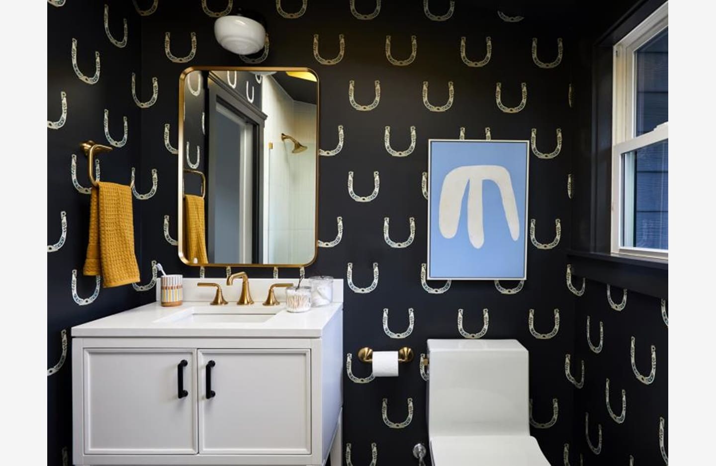 A bathroom with black and white wallpaper, toilet and sink.