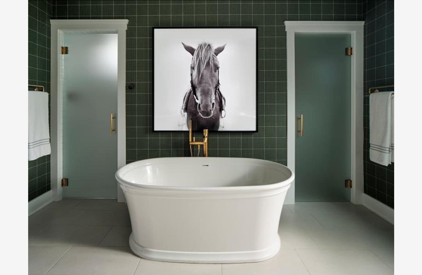 A bathroom with a tub and a horse picture on the wall.