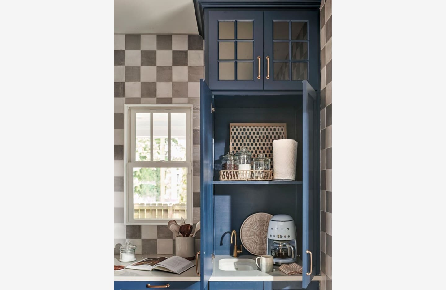 A kitchen with blue cabinets and checkered walls.