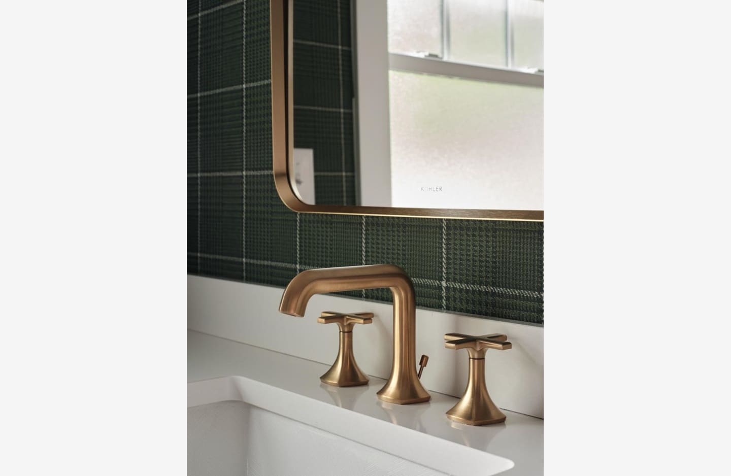 A bathroom sink with two faucets and a mirror.