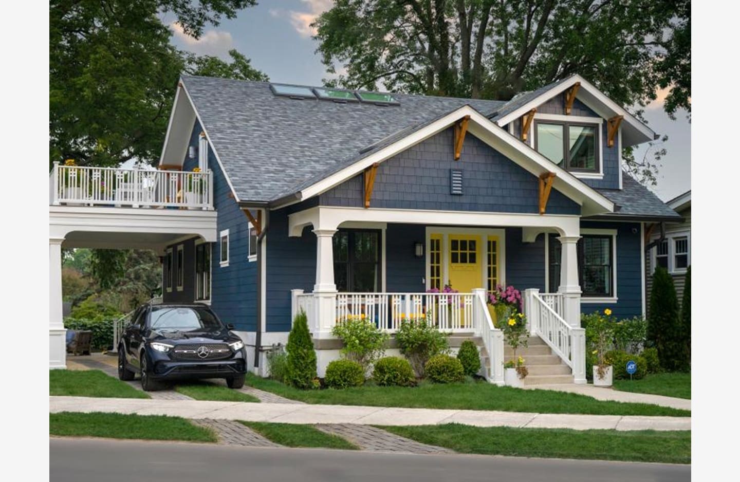 A blue house with a car parked in front of it.