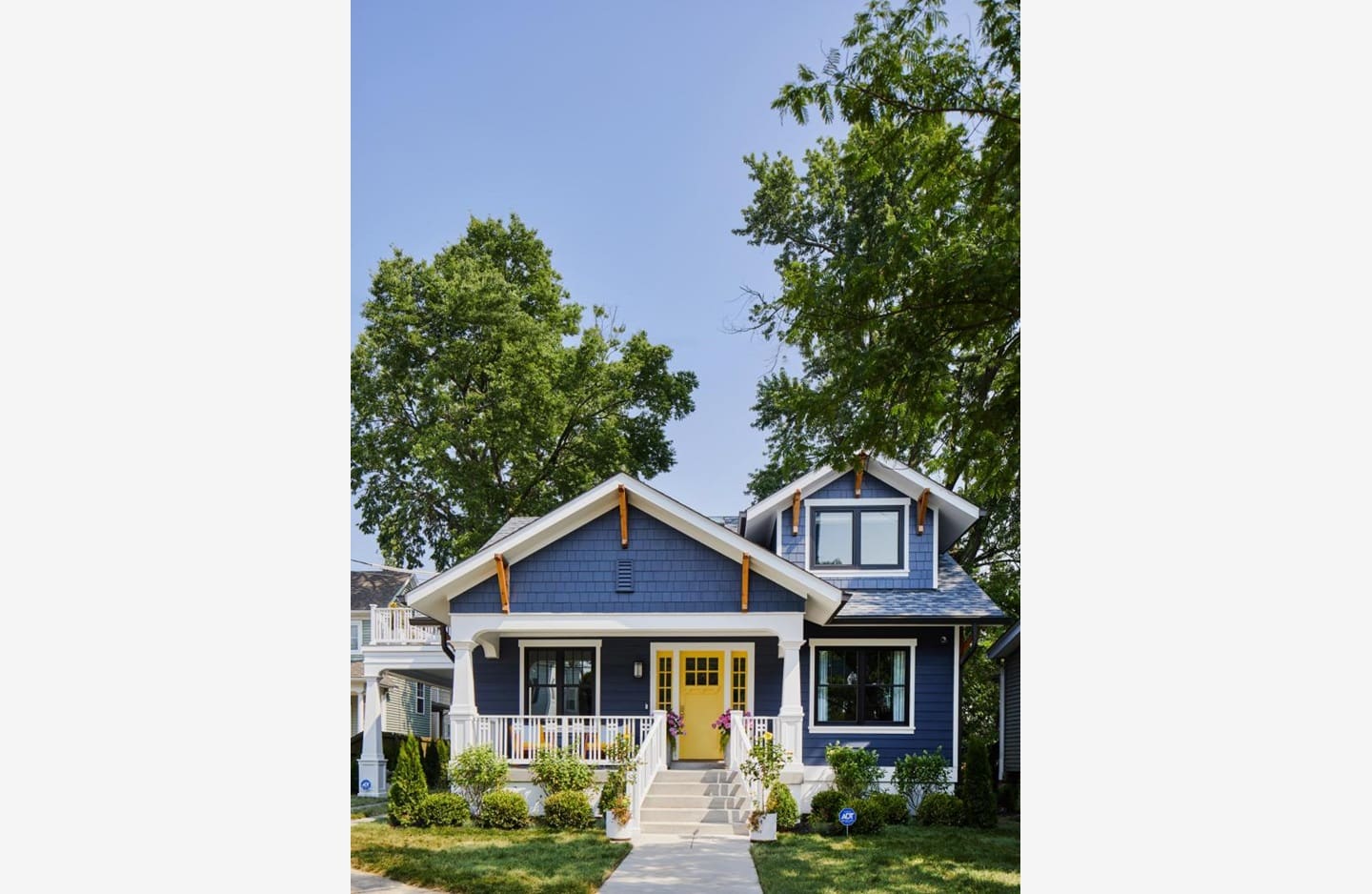 A blue house with yellow door and white trim.