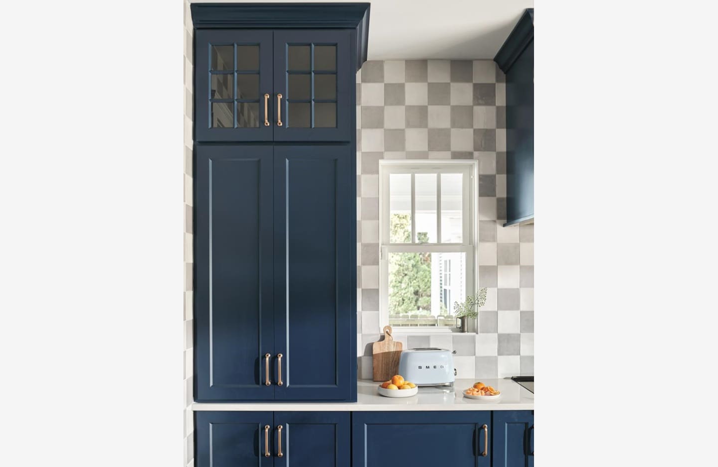 A kitchen with blue cabinets and white counters