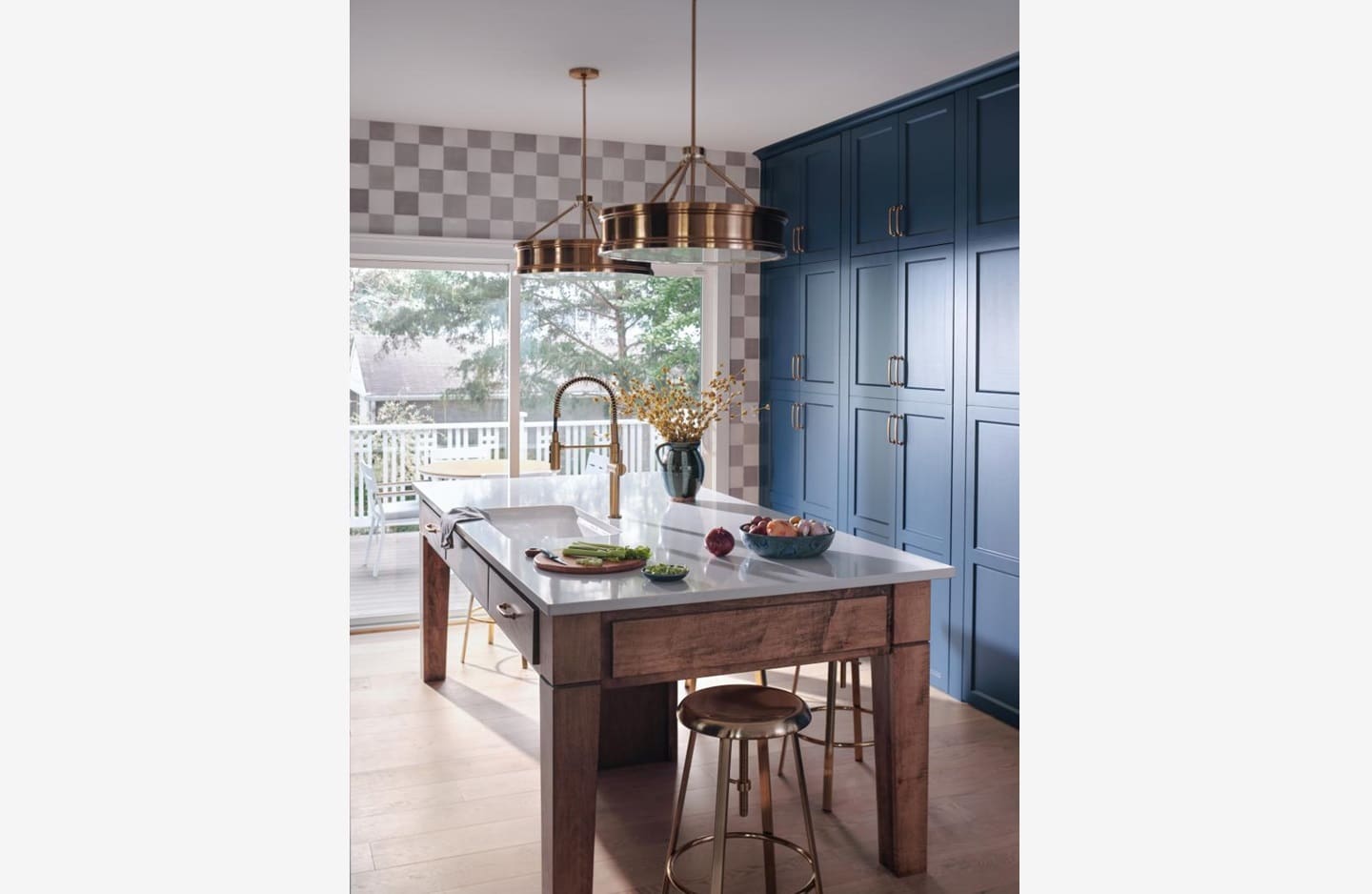 A kitchen with blue cabinets and a large window.